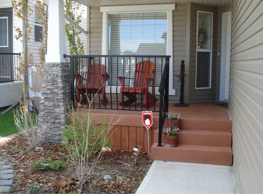 a front porch of a house with 2 rocking chairs on it.