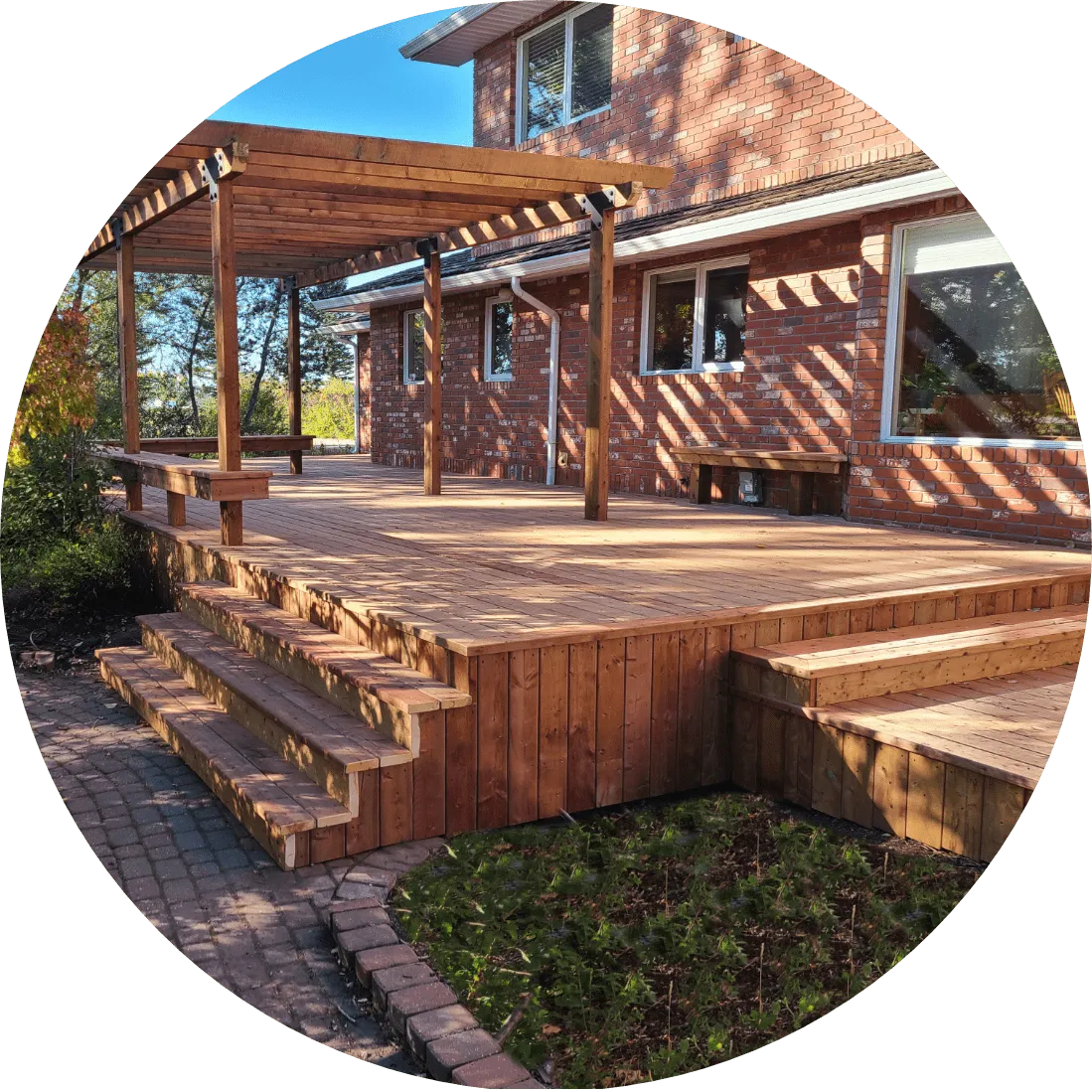 a deck in the backyard of a red brick home
