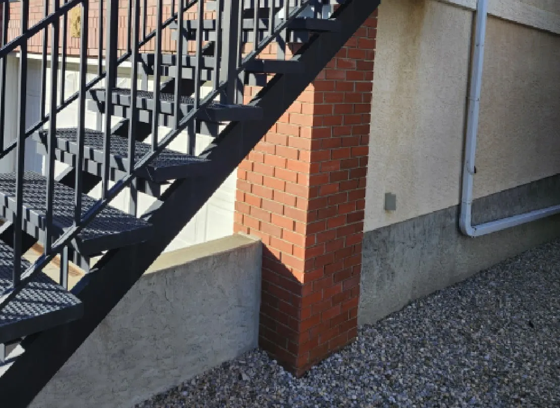 black stairs that are coming down off a deck into the back yard