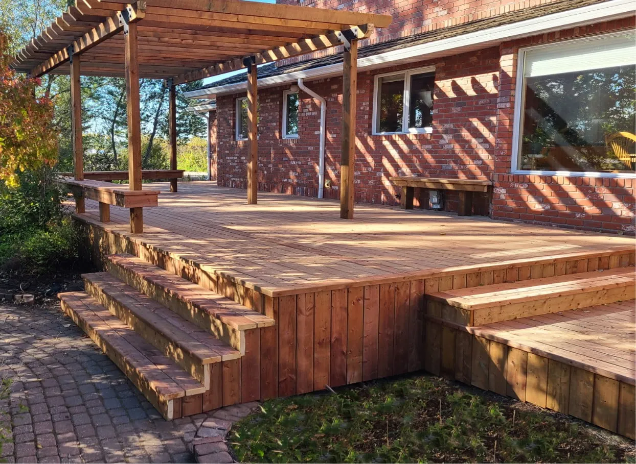 a huge backyard deck with pergola